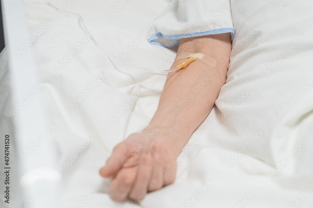 Close-up of senior patient lying under a drip in the hospital bed Close-up of senior patient lying under a drip in the hospital bed