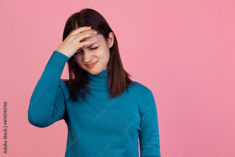 One emotive young girl in warm winter blue sweater isolated on pink studio background. Concept of emotions One emotive young girl in warm winter blue sweater isolated on pink studio background. Concept of emotions