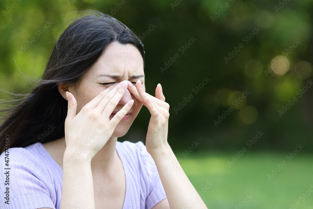 Asian woman scratching itchy eyes in a park Asian woman scratching itchy eyes in a park