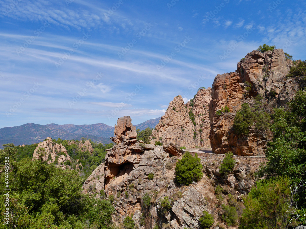 Scenic road D81 winding through the red cliffs of the Calanche, UNESCO world heritage site. Corsica, France.