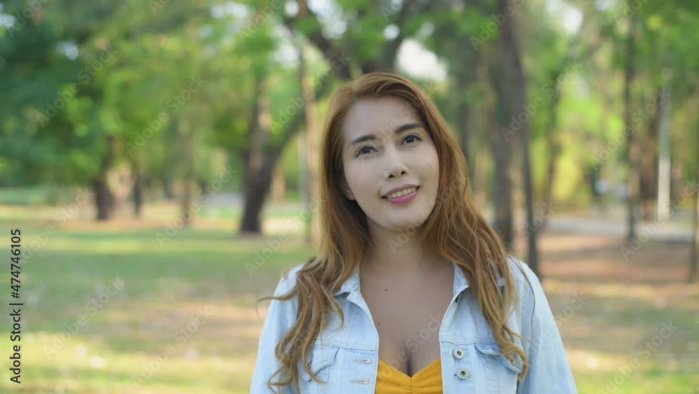 Holiday concept of 4k Resolution. Asian woman smiling happily in the park. Holiday concept of 4k Resolution. Asian woman smiling happily in the park.