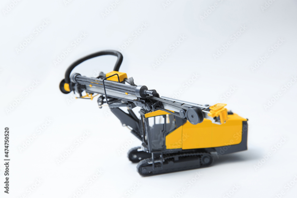 Drilling machine for contour drilling of boreholes for blast preparation in the quarry. The layout of a small quarry drilling rig on a white background. Drilling machine for contour drilling of boreholes for blast preparation in the quarry. The layout of a small quarry drilling rig on a white background.