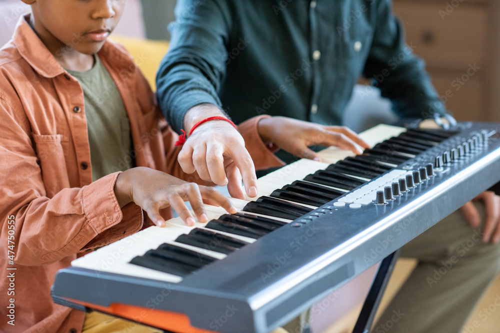 Hand of young teacher of music pointing at one of keys of piano keyboard  during lesson in home environment Stock Photo | Adobe Stock