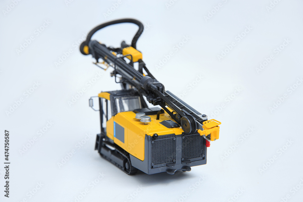 Drilling machine for contour drilling of boreholes for blast preparation in the quarry. The layout of a small quarry drilling rig on a white background. Drilling machine for contour drilling of boreholes for blast preparation in the quarry. The layout of a small quarry drilling rig on a white background.