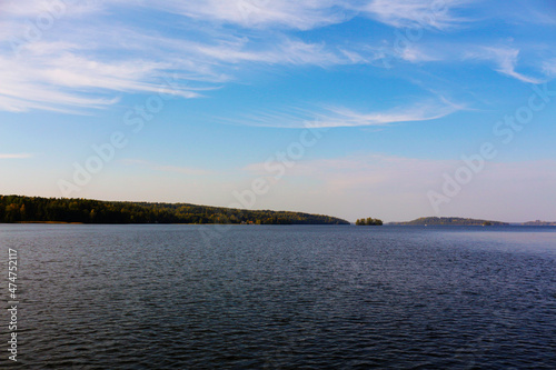 A beautiful landscape with a lake and blue sky and amazingly shaped clouds