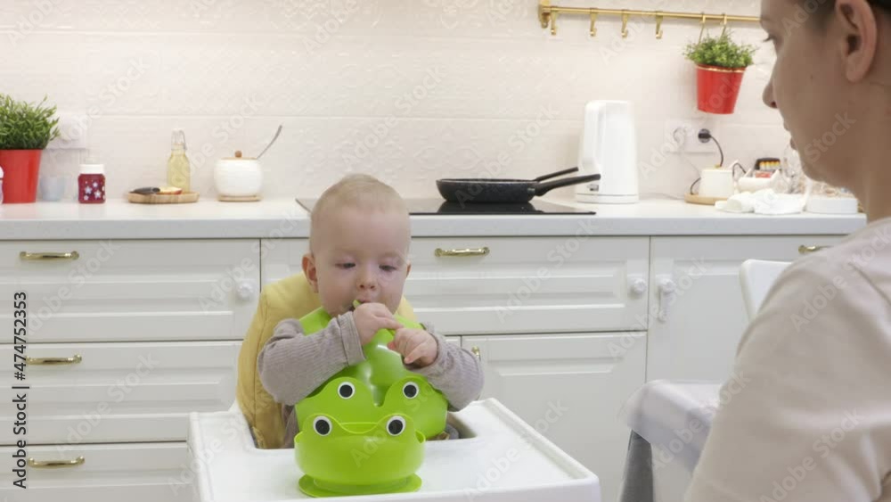 Teaching baby to self feed using a spoon, mother teaches her 8 month ...
