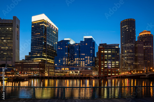 Panoramic picturesque city view of Boston Harbour and Seaport Blvd evening and night time, Massachusetts. An intellectual, technological and political center. Building exteriors of financial downtown.