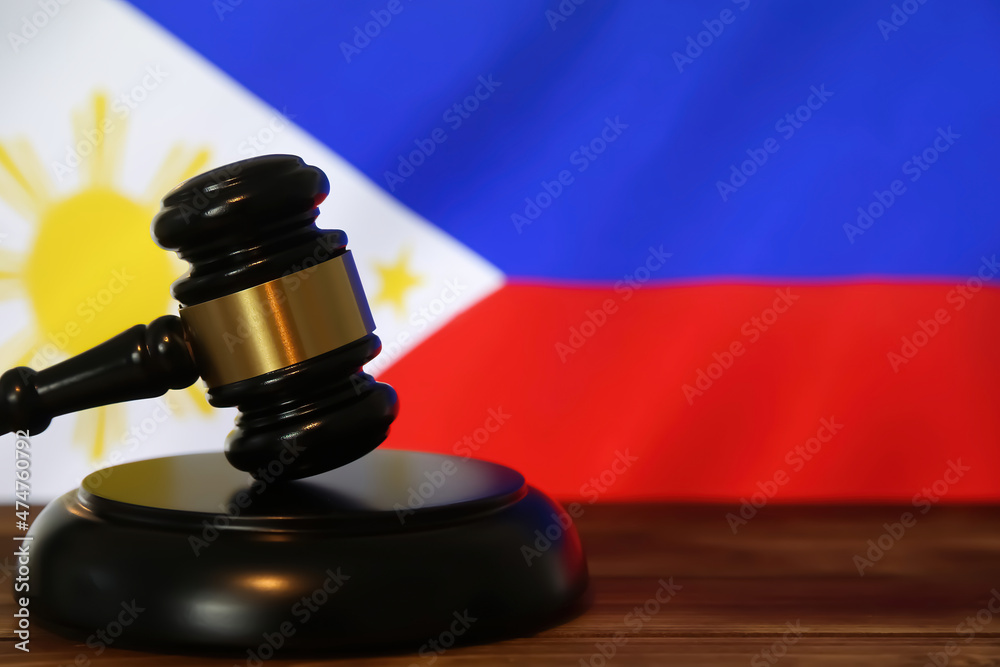 Closeup of isolated judge wood gavel with blurred philippine flag background (focus on hammer head)