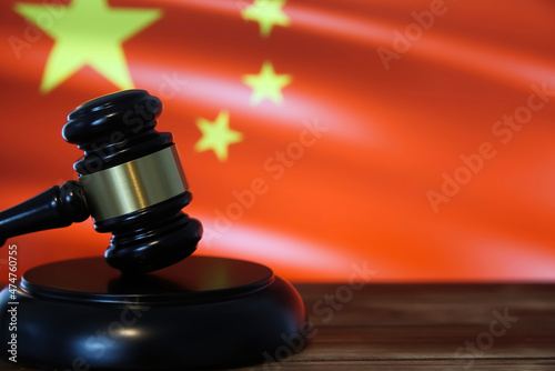 Photography Closeup of isolated judge wood gavel with blurred chinese flag background (focus