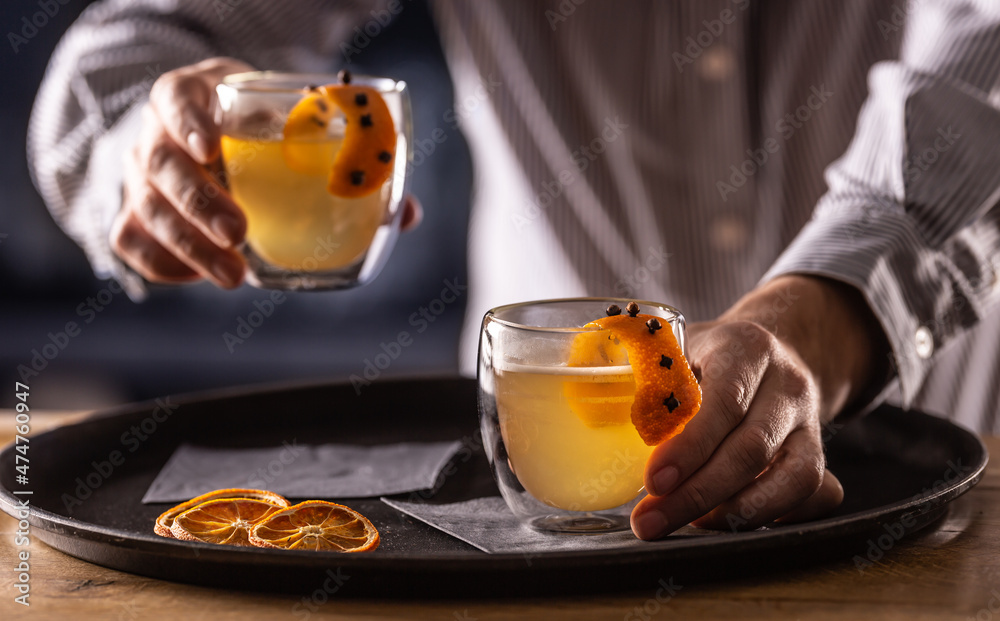 The bartender serves a winter drink HOT TODDY in the pub or restaurant The bartender serves a winter drink HOT TODDY in the pub or restaurant