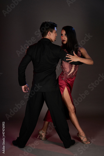 tango ballroom tango couple of latin woman and asian man, studio shot black background