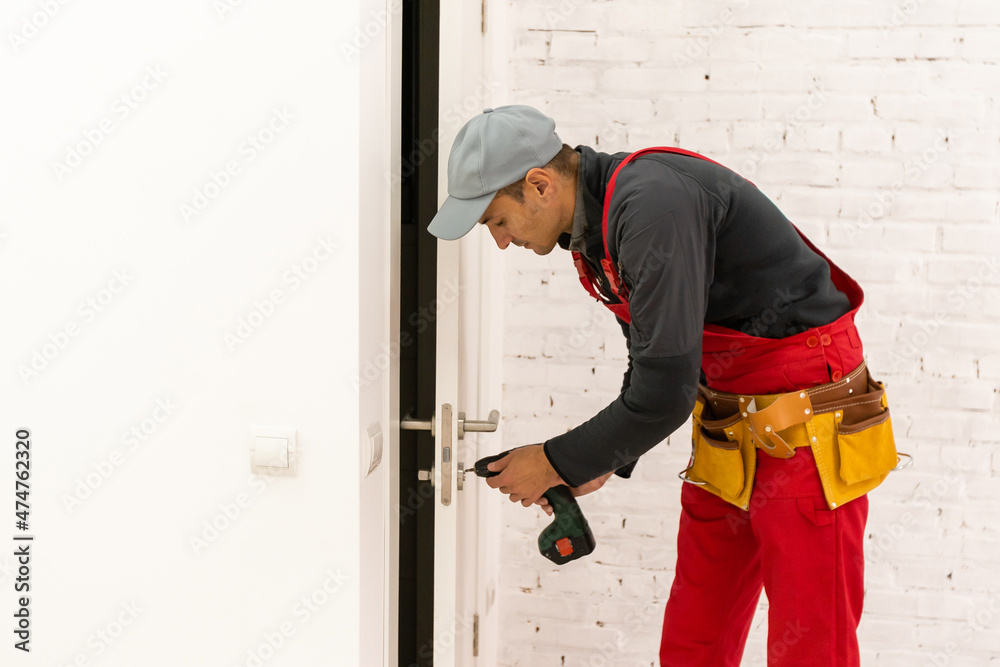Man fixing locks with screwdriver in a new house Man fixing locks with screwdriver in a new house