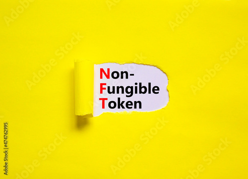 NFT non-fungible token symbol. Concept words NFT non-fungible token on white paper. Beautiful yellow background, copy space. Business and NFT non-fungible token concept.