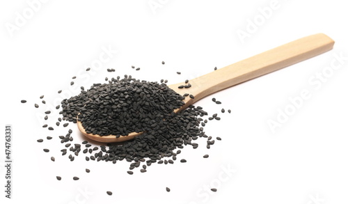 Black sesame seeds pile in wooden spoon isolated on white  