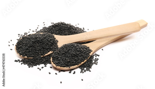 Black sesame seeds pile in wooden spoon isolated on white  