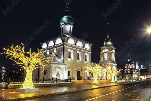 Varvarka Street with the ancient temple of Maxim the Confessor, the bell tower and the Temple of Varvara the Great Martyr at night on Christmas holidays. Moscow, Russia