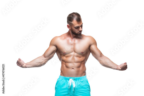 Front view of muscular and fit young bodybuilder fitness male model demonstrating his biceps isolated on white background