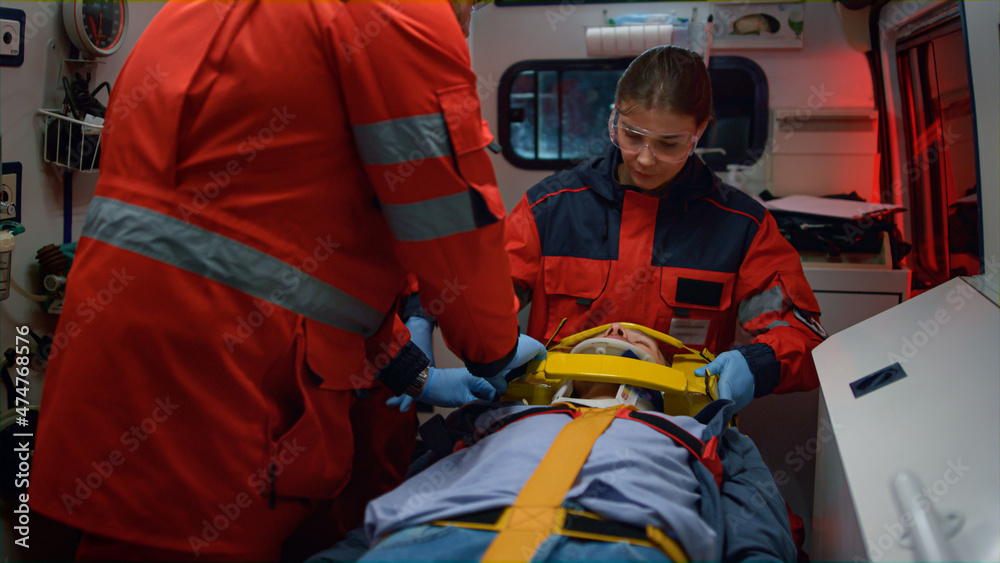 EMS paramedics providing first aid procedure to patient in emergency vehicle EMS paramedics providing first aid procedure to patient in emergency vehicle