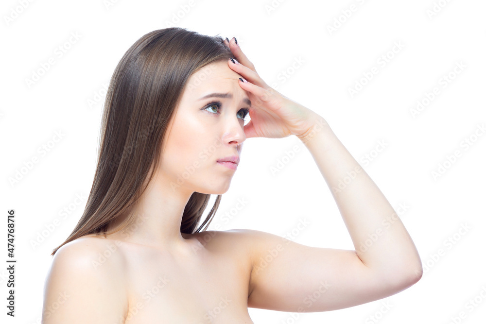 Photo of a young beautiful girl experiencing an attack of severe headache, standing with her hands near her head on a white background