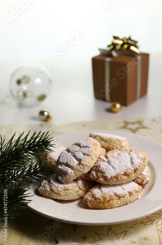 Ricciarelli, dolce tipico natalizio senese a base di mandorle su sfondo bianco. Decorazioni natalizie. Dolci della tradizione italiana