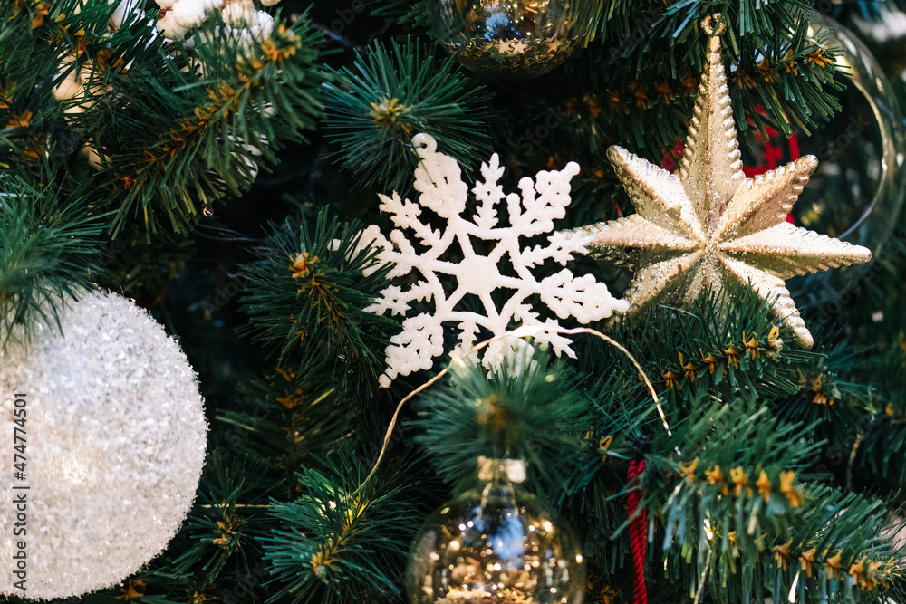 Gold and white christmas balls with sparkles on a christmas tree close-up