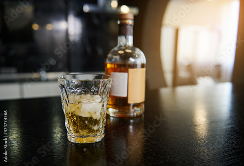 Εκτύπωση καμβά Focus on a faceted glass with a bottle of whiskey or other strong alcoholic drin