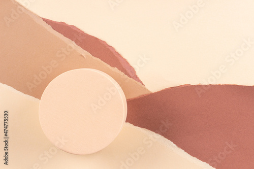 Abstract trendy composition with empty round podium platform for product presentation and curve shaped torn beige brown paper background. Top view