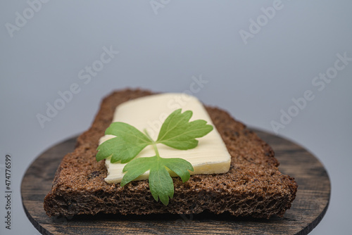 A piece of butter with herbs on toasted rye bread