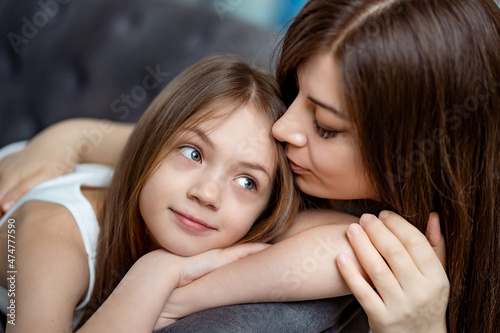 Mom gently hugs the teen's daughter. trust between parents and children