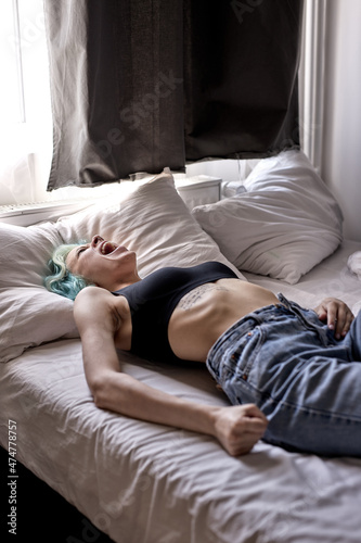 Depressed young woman lying in bed . Mental problems with depression and bulimia.Extremely depressed woman is afraid of something. female suffer from insomnia mental problem abuse violence concept