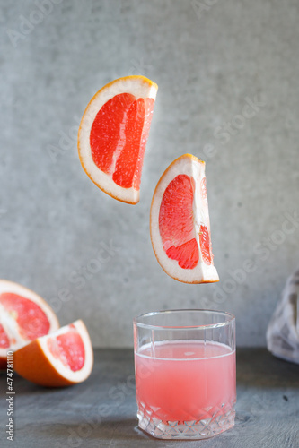Glass of grapefruit juice on black surface