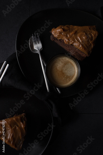 Canvas-taulu Breakfast scene with a couple of black dishes with two chocolate cake slices and a cup of coffee in the middle