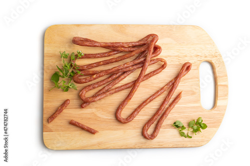 Polish smoked pork sausage kabanos on cutting board isolated on white background. Top view, close up. photo