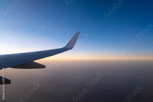 flying and traveling, view from airplane window on the wing on sunset time