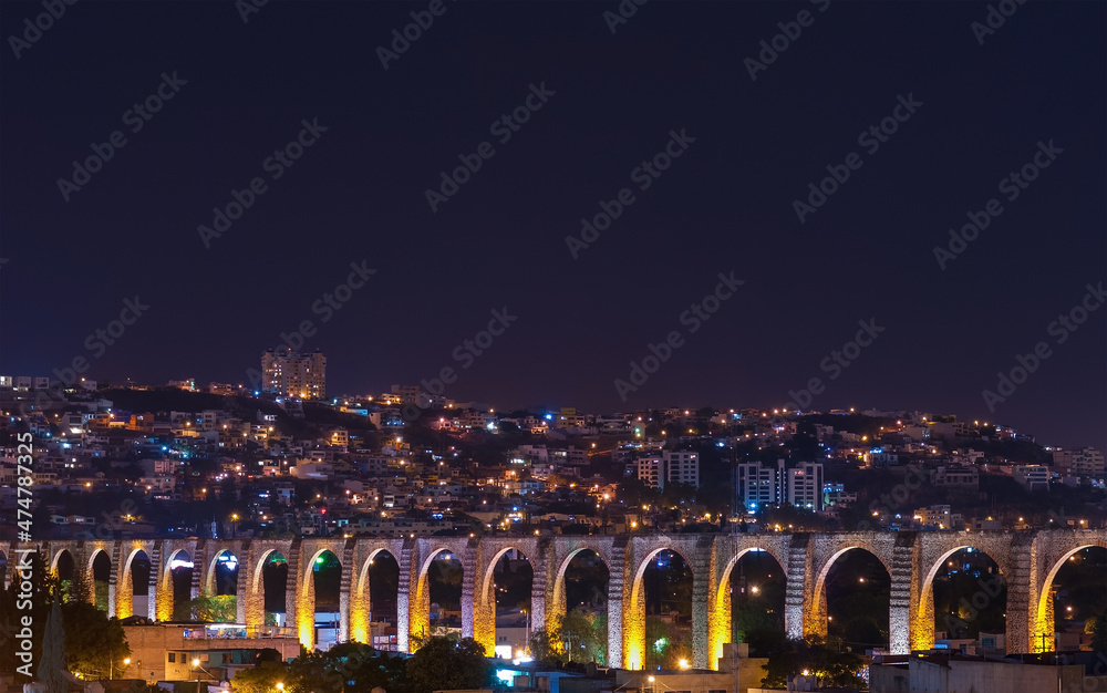 Fototapeta premium The viaduct of Queretaro city and its skyline at night, Mexico.