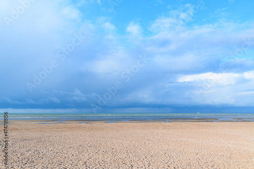 The storm over the sandy beach in Europe, France, Normandy, Ouistreham, in summer, on a sunny day.