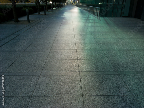 ビルの窓で反射した光で、緑色に輝く歩道の路面