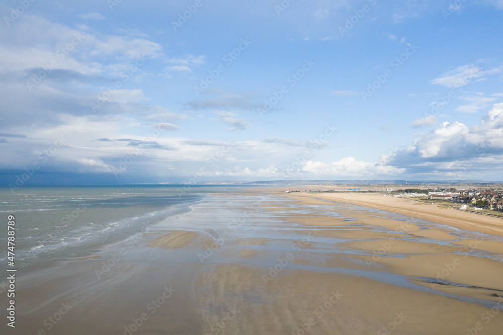 The Channel Sea and the sandy beach of Ouistreham in Europe, France, Normandy in summer on a sunny day.