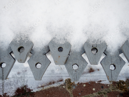 Wooden fence denticles. Items in the snow. photo