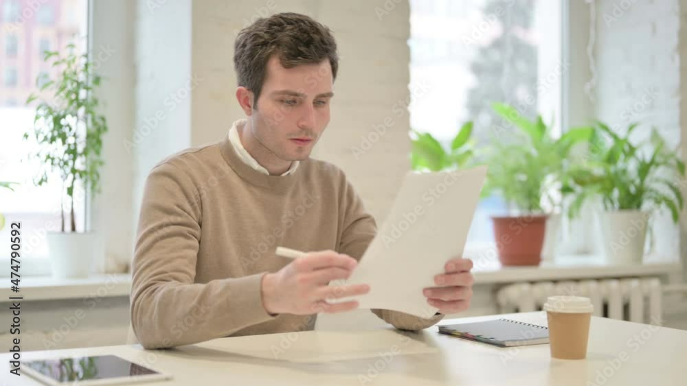 Man Reading Reports while Sitting in Office Man Reading Reports while Sitting in Office