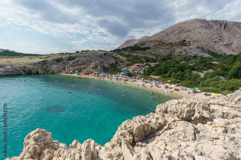 Beach at adriatic sea with karst rocky landscape and mountain on Krk island, Croatia
