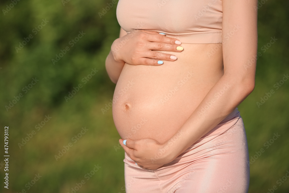 Young pregnant woman training in park, closeup Young pregnant woman training in park, closeup