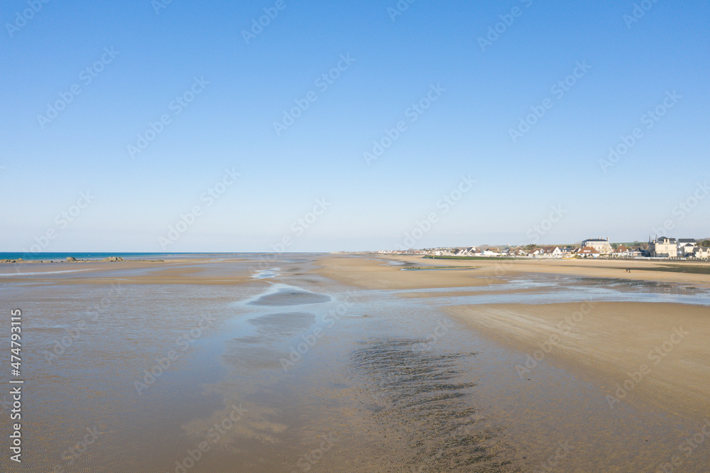 The long sandy beach of Gold beach in Asnelles in Europe, France, Normandy, towards Arromanches les Bains, in summer, on a sunny day.