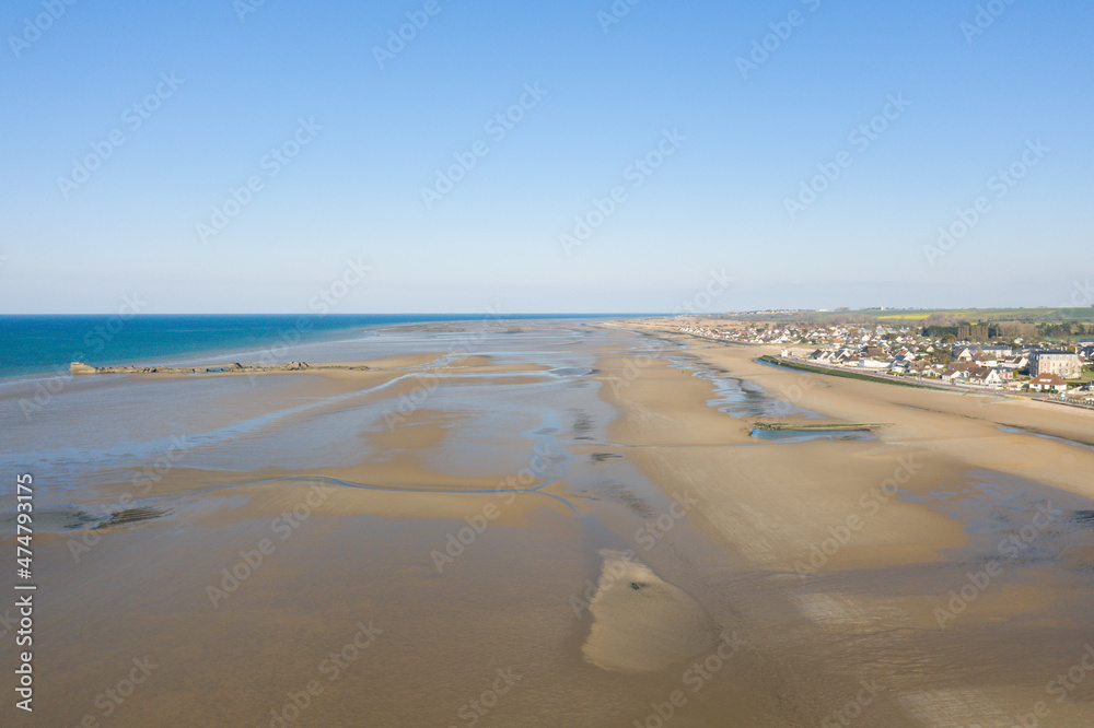 The fine sand beach in front of the Channel Sea at Asnelles in Europe, France, Normandy, towards Arromanches les Bains, in summer, on a sunny day.