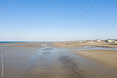 The long sandy beach of Gold beach in Asnelles in Europe, France, Normandy, towards Arromanches les Bains, in summer, on a sunny day.
