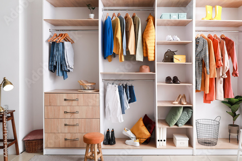 Walk-in closet with stylish female clothes photo
