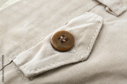 Closeup view of button on beige pants