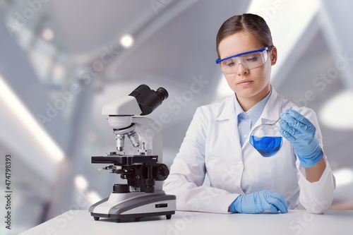 Biotechnologist scientist researching with a microscope in pharma lab. Modern laboratory