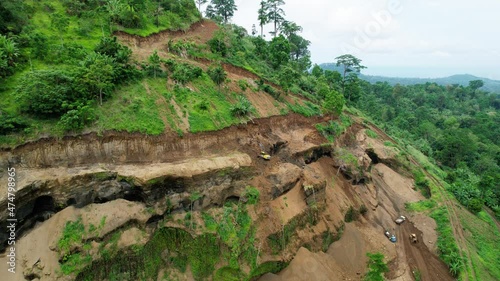 Aerial view of excavators restoring a landslide area, in a African rainforest - rising, drone shot photo