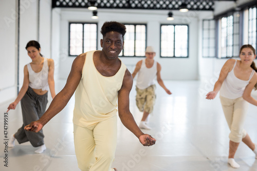 Four dancers exercising swing dance movements in large ball room